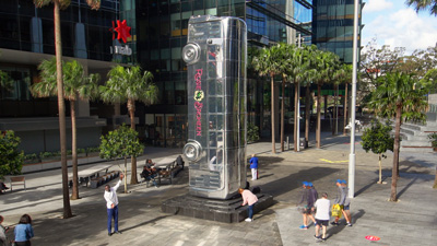 Full-size chrome bus sculpture installed vertically in Parramatta