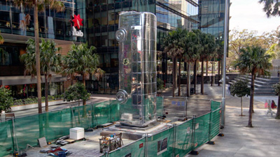 A large chrome bus sculpture protruding vertically out of the walkway.