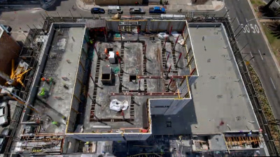 Camera mounted on crane looking down at construction site during a cement pour.