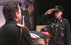 Two actors in German army uniforms saluting in a drama film production.